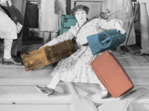 Woman struggling with three suitcases.